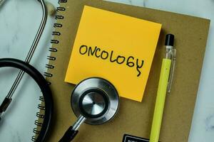 Concept of Oncology write on sticky notes isolated on Wooden Table. photo