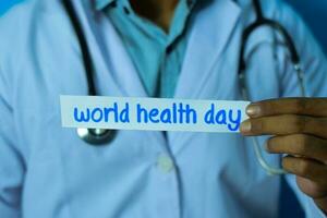 Doctor holding a card with text world health day. Medical and healthcare concept. photo