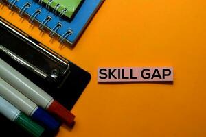 Skill Gap write on sticky notes. Isolated on orange table background photo