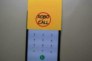 Robocall write on a sticky note isolated on office desk. photo