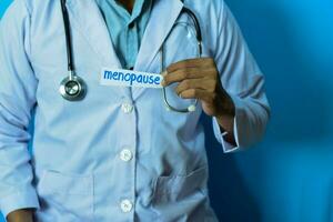 Doctor holding a card with text Menopause. Medical and healthcare concept. photo