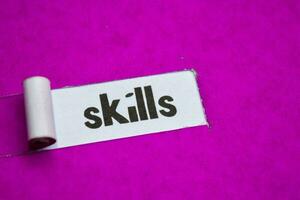 Skills text, Inspiration, Motivation and business concept on purple torn paper photo