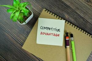 Concept of Competitive Advantage write on sticky notes isolated on Wooden Table. photo
