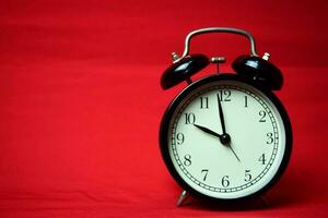 Clock ticking to 10 o'clock on the red background photo