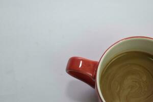 Close up hot cappuccino coffee in a red cup isolated on a white background photo