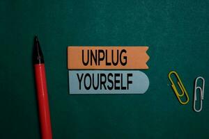 Unplug Yourself write on a sticky note isolated on Office Desk photo