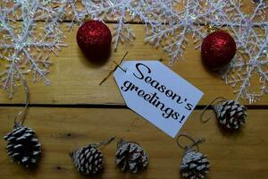 Seasons Greetings write on laber with wooden backgroud. Frame of Christmas Decoration. photo