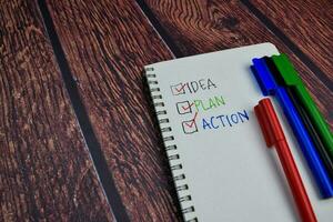 Idea Plan Action write on a book and checklist Isolated on wooden table background photo