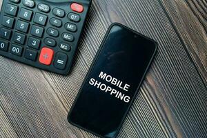 Mobile Shopping write on Smartphone isolated on office desk. photo