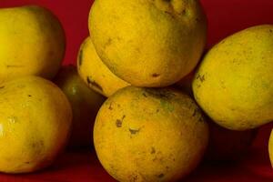 Fresh orange fruit in the red background photo