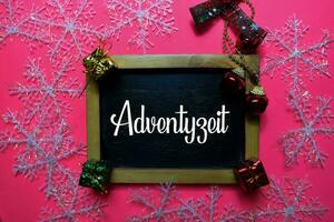 Adventszeit write on black board isolated on Pink backgroud. It means Advent Season. Frame of Christmas Decoration. photo