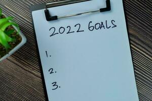 Concept of 2022 Goals write on a paperwork isolated on Wooden Table. photo