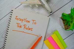 Exception To The Rules write on a book isolated on Wooden Table. photo