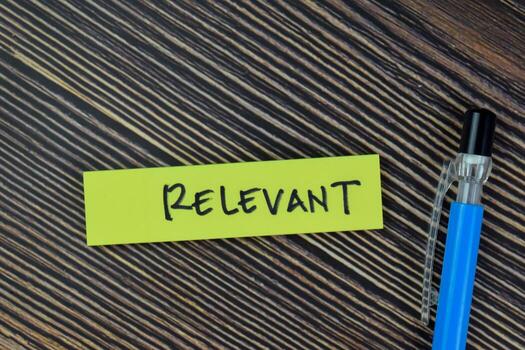 Concept of Relevant write on sticky notes isolated on Wooden Table. photo