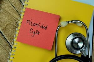 Concept of Pilonidal Cyst write on sticky notes with stethoscope isolated on Wooden Table. photo