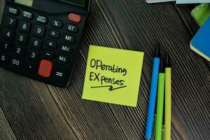 Operating Expenses write on sticky notes isolated on office desk. photo