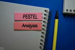 Pestel Analysis write on sticky note isolated on Office Desk. photo