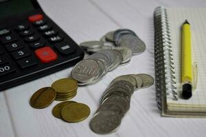 Calculator and the stack of coint isolated on office desk. calculating salary or tax concept photo