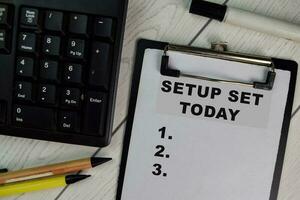 Setup Set Today write on a paperwork and supported by additional services isolated on Wooden Table. photo