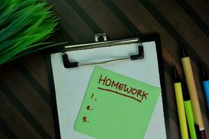 Homework write on sticky notes isolated on Wooden Table. photo