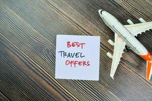 Concept of Best Travel Offers write on sticky notes isolated on Wooden Table. photo