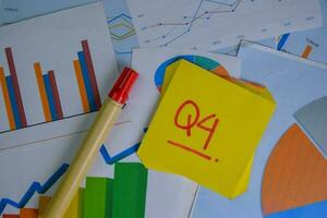 Q4 - 4th Quarter Period write on sticky notes isolated on Wooden Table. Stock market concept photo