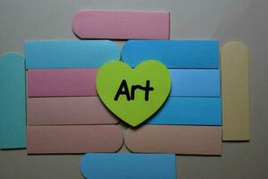 Art write on a sticky note isolated on office desk. photo