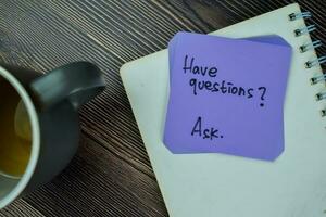 concepto de tener preguntas pedir escribir en pegajoso notas aislado en de madera mesa. foto