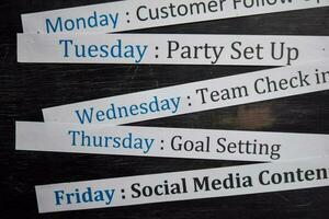 Close up making agenda weekly schedule on personal organizer. Business and entrepreneur concept. Isolated on blackboard photo