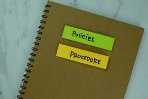 Concept of Policies and Procedure write on a book isolated on Wooden Table. photo