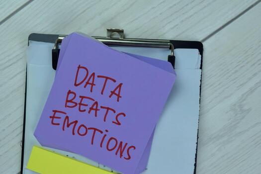 Concept of Data Beats Emotions write on sticky notes isolated on Wooden Table. photo