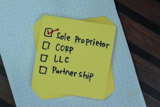 Concept of Sole Proprietor write on sticky notes isolated on Wooden Table. photo