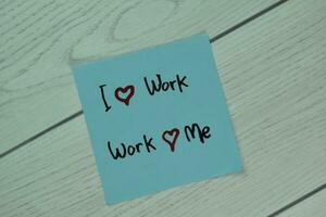 I Love Work and Work Love Me write on sticky notes isolated on Wooden Table. photo