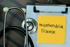 Concept of Mitochondrial Disease write on paperwork isolated on Wooden Table. photo