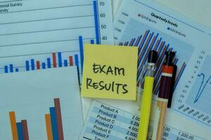 Concept of Exam Results write on sticky notes isolated on Wooden Table. photo