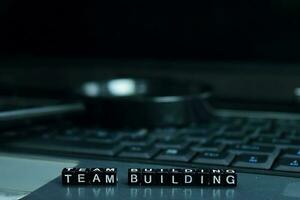 Team Building text wooden blocks in laptop background. Business and technology concept photo