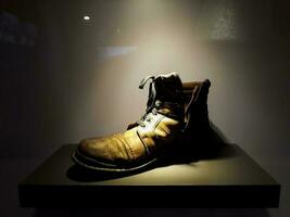 old boots in diplay with lighting on black background. BEKASI, INDONESIA, APRIl 8, 2019 photo