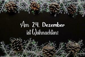 Am 24. Dezember Ist Weihnachten Text isolated on black background. It means Merry Christmas. Frame of Christmas Decoration. photo