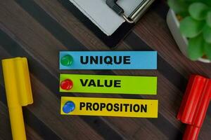 Unique Value Proposition write on sticky notes isolated on Wooden Table. photo