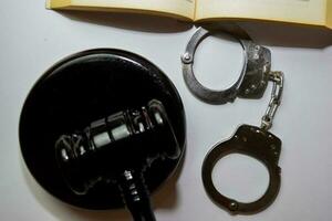 handcuffs and black gavel isolated on white background. Justice and law concept photo