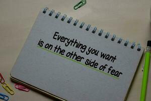 Everything you want is on the other side of fear write on a book isolated on Office Desk photo