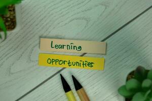 Learning Opportunities write on sticky notes isolated on Wooden Table. photo