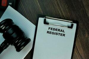 Federal Register write on a paperwork isolated on Wooden Table. Business Concept photo