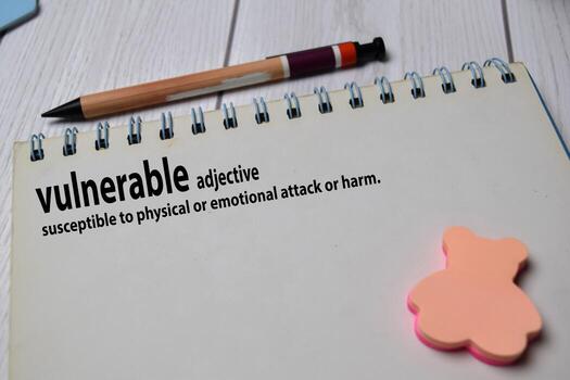 Definition of Vulnerable word with a meaning on a book. dictionary concept photo