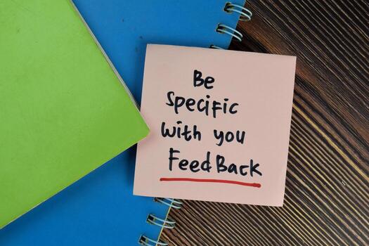 Be Specific With You Feedback write on sticky notes isolated on Wooden Table. photo