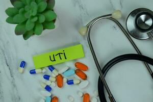 UTI write on sticky notes isolated on Wooden Table. photo
