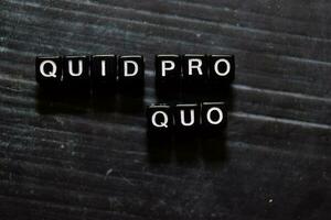 Quid Pro Quo in Latin on wooden cubes. On table background photo