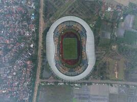 Aerial view of the Beautiful scenery Gelora Bandung Lautan Api  Football or Soccer Stadium in the Morning with Blue Sky. Bandung, Indonesia, November 22, 2022 photo