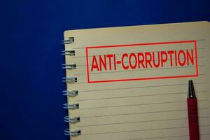 Anti-Corruption write on a book isolated on blue background. photo