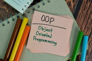 OOP - Object Oriented Programming write on sticky notes isolated on Wooden Table. photo